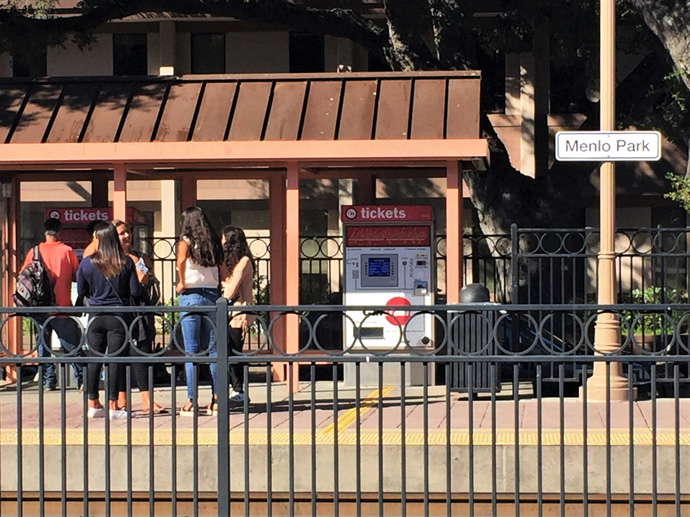 people chatting as they wait for the train